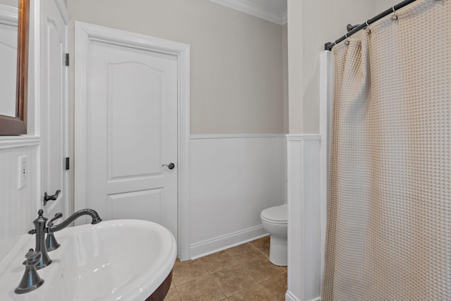 bathroom with tile patterned floors, toilet, sink, ornamental molding, and curtained shower