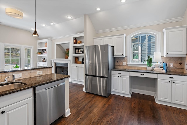 kitchen with stainless steel appliances, white cabinetry, hanging light fixtures, and dark stone counters