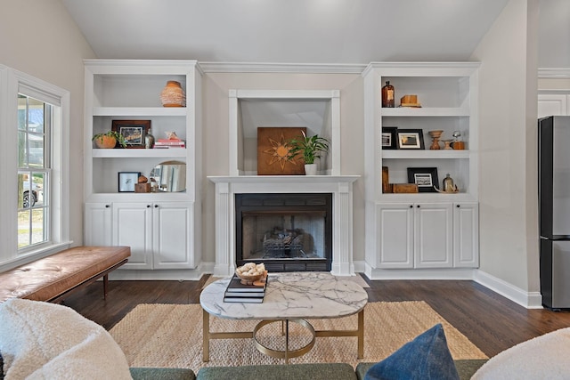 living area featuring lofted ceiling, dark hardwood / wood-style floors, and built in features