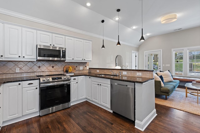 kitchen featuring white cabinetry, dark stone counters, hanging light fixtures, kitchen peninsula, and stainless steel appliances