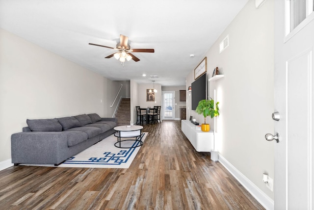 living room featuring ceiling fan and dark hardwood / wood-style floors