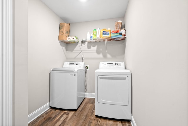 clothes washing area featuring dark wood-type flooring and washing machine and clothes dryer