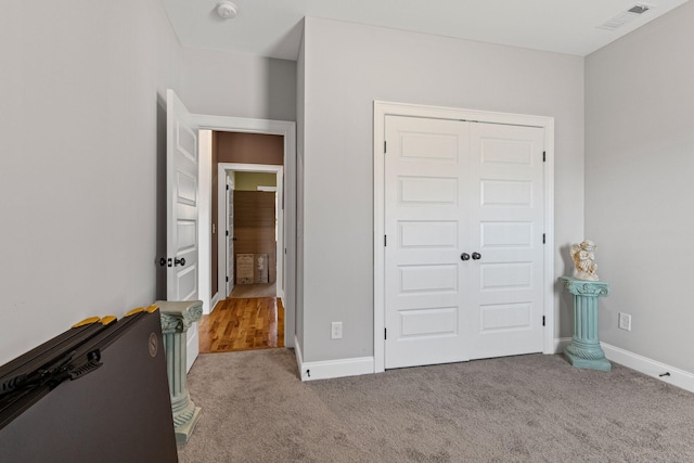 unfurnished bedroom with light carpet and a closet