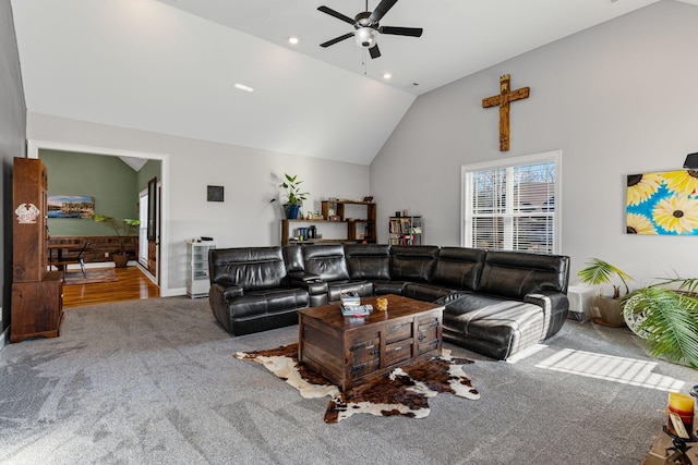 carpeted living room with ceiling fan and high vaulted ceiling