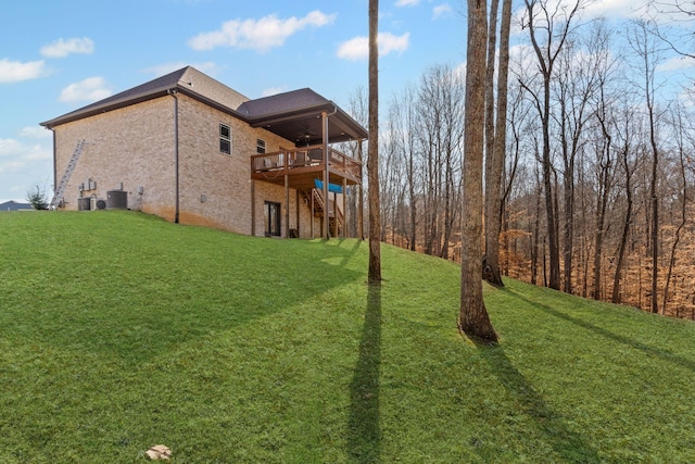 view of yard with central AC and a deck