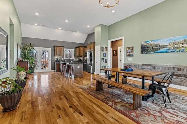 dining area featuring vaulted ceiling and light hardwood / wood-style flooring