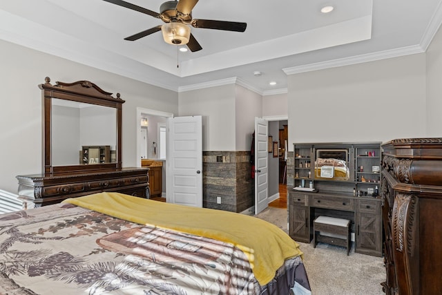 bedroom featuring light carpet, a tray ceiling, crown molding, and ceiling fan