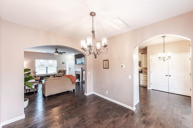 dining room featuring dark hardwood / wood-style flooring and ceiling fan with notable chandelier