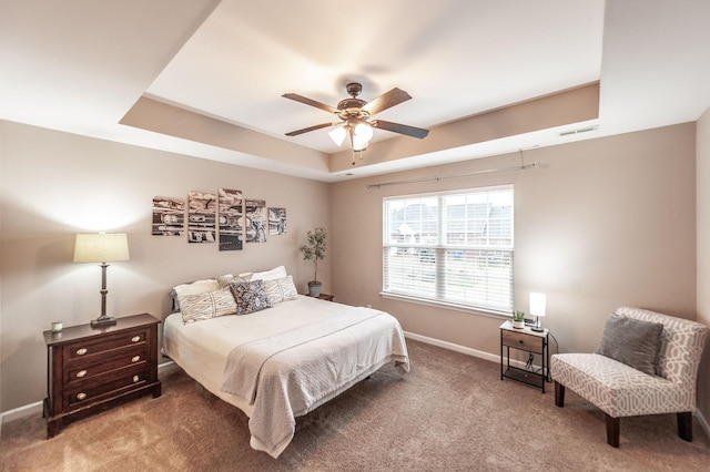 bedroom featuring light carpet, a raised ceiling, and ceiling fan