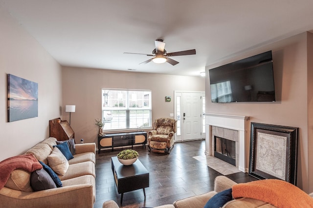 living room featuring hardwood / wood-style flooring, ceiling fan, and a fireplace