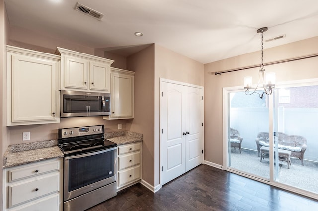 kitchen with light stone counters, appliances with stainless steel finishes, dark hardwood / wood-style flooring, and hanging light fixtures