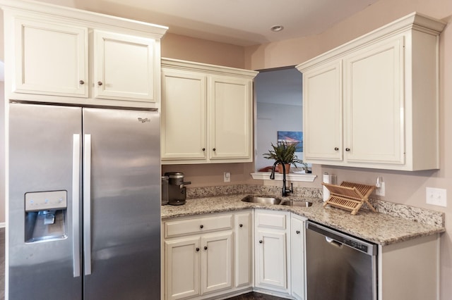 kitchen with stainless steel appliances, sink, and light stone counters