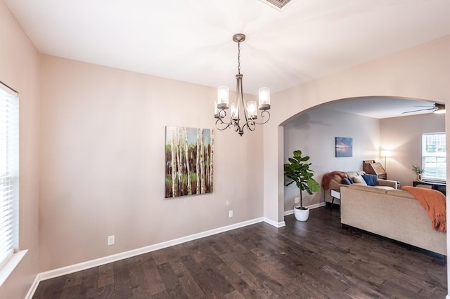 dining space featuring dark hardwood / wood-style floors and ceiling fan with notable chandelier