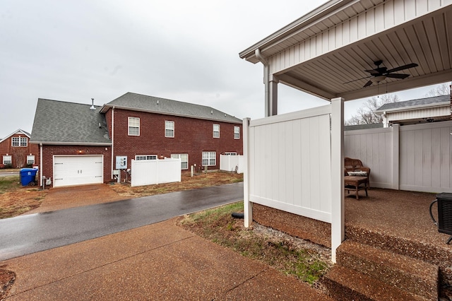 view of property exterior featuring a garage and ceiling fan