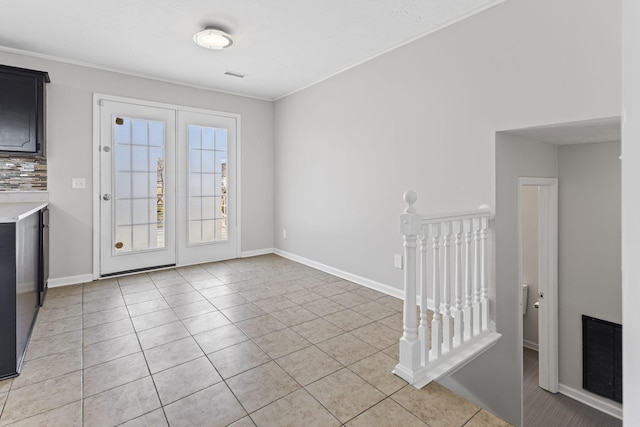 interior space featuring crown molding and light tile patterned floors