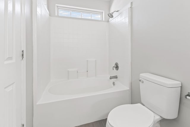 bathroom with bathtub / shower combination and toilet