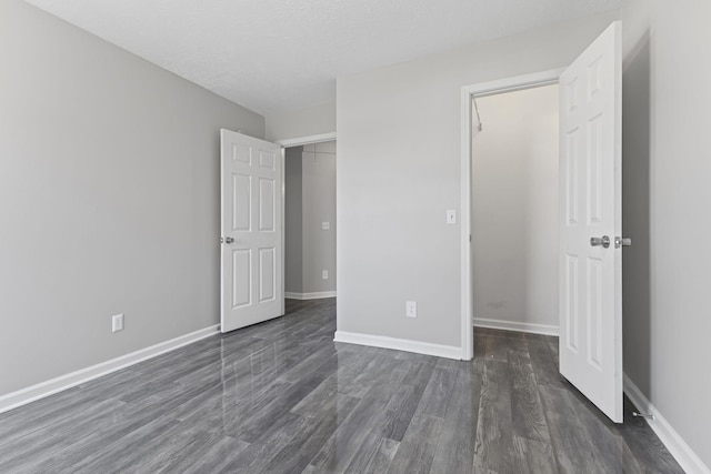 unfurnished bedroom with dark hardwood / wood-style flooring and a textured ceiling