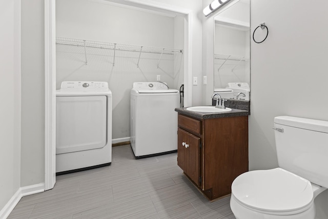 bathroom with vanity, toilet, and separate washer and dryer