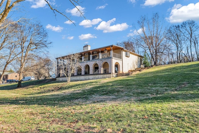 exterior space with a balcony and a lawn