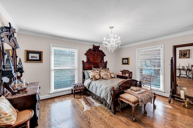 bedroom with an inviting chandelier, crown molding, and light hardwood / wood-style flooring