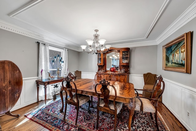 dining space featuring an inviting chandelier, ornamental molding, and dark hardwood / wood-style floors