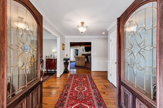 entrance foyer with dark wood-type flooring and ornamental molding