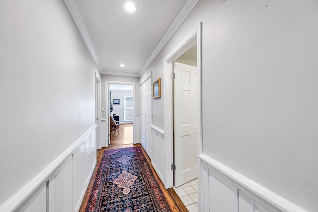 hallway featuring ornamental molding and light tile patterned floors