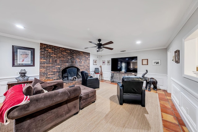 tiled living room featuring crown molding, a fireplace, and ceiling fan