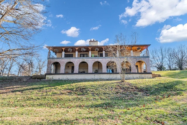 view of front of property featuring a front lawn and a balcony