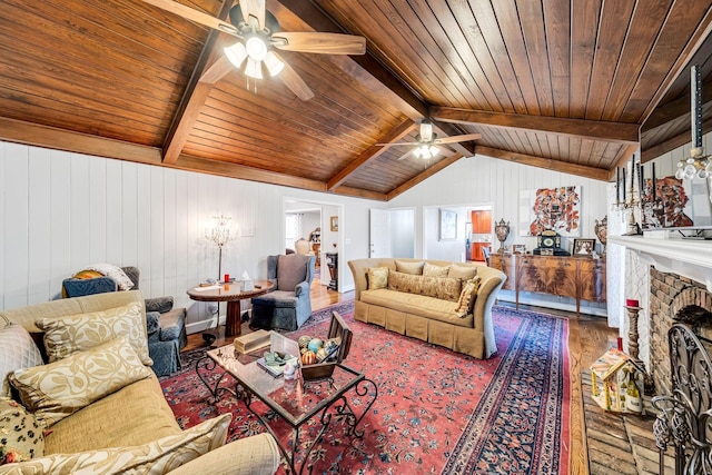 living room featuring lofted ceiling with beams, ceiling fan, hardwood / wood-style floors, and a fireplace