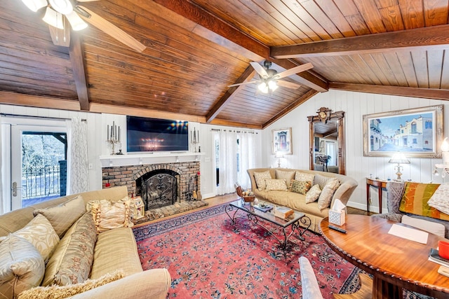 living room with a brick fireplace, plenty of natural light, hardwood / wood-style floors, and ceiling fan