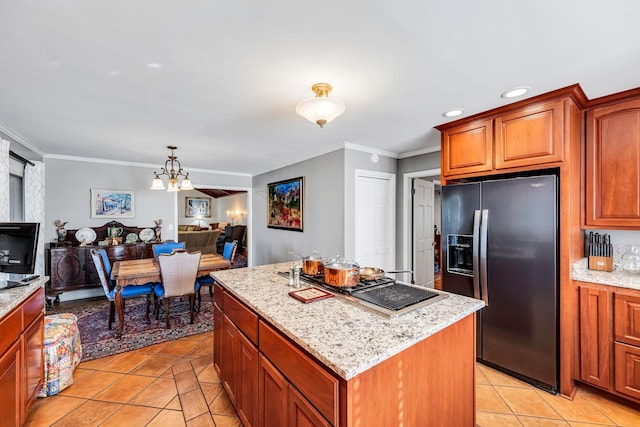 kitchen with a chandelier, light tile patterned floors, ornamental molding, refrigerator with ice dispenser, and a kitchen island