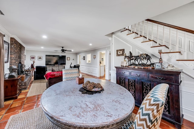 tiled dining space with ornamental molding and ceiling fan