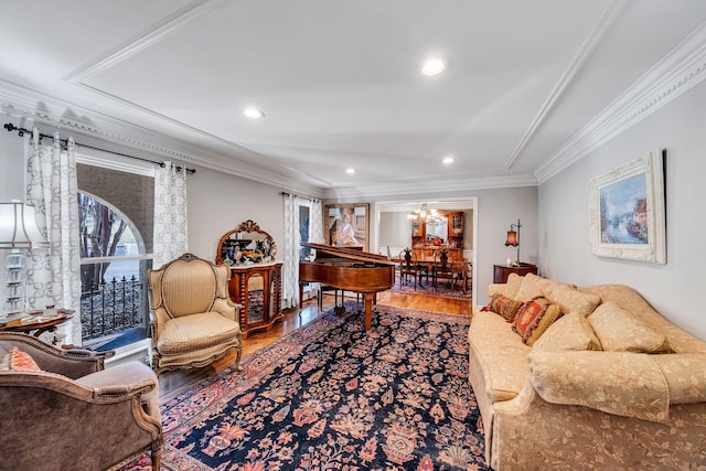 living room with wood-type flooring, a chandelier, and crown molding