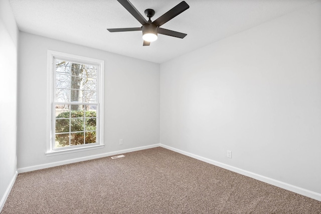 unfurnished room featuring plenty of natural light, ceiling fan, and carpet