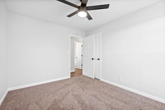 carpeted spare room with ceiling fan