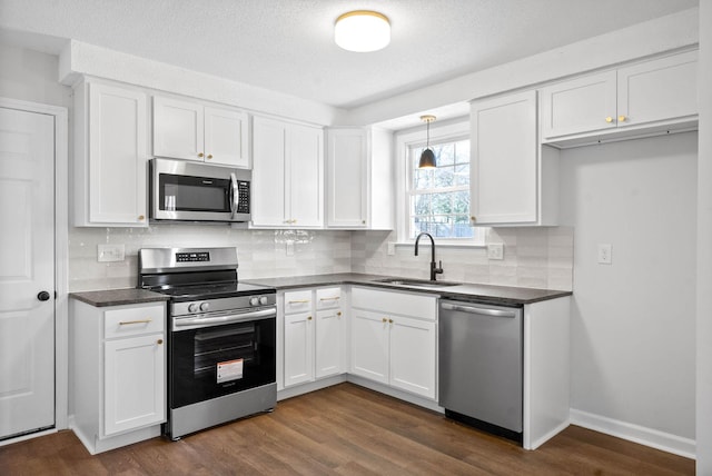 kitchen featuring white cabinetry, appliances with stainless steel finishes, sink, and dark hardwood / wood-style floors