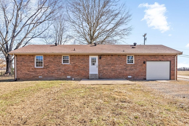 back of house with a garage, a patio, and a lawn