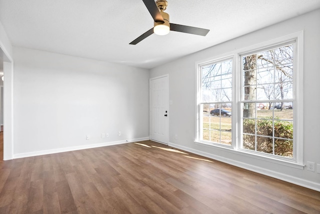 spare room featuring ceiling fan, a wealth of natural light, and wood-type flooring