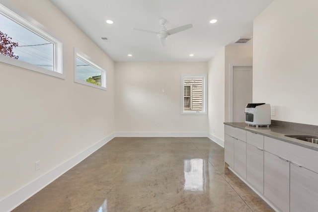 unfurnished dining area with ceiling fan and concrete floors