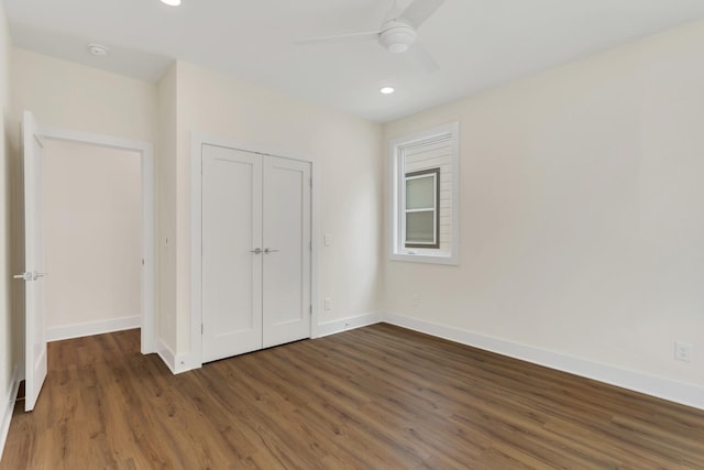 unfurnished bedroom with dark wood-type flooring, a closet, and ceiling fan