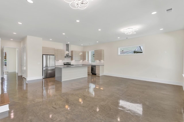 kitchen featuring sink, hanging light fixtures, a kitchen island, stainless steel appliances, and wall chimney range hood