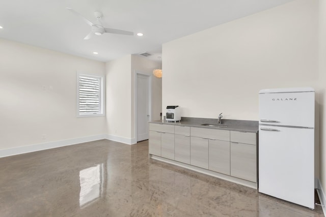 kitchen featuring white refrigerator, ceiling fan, and sink