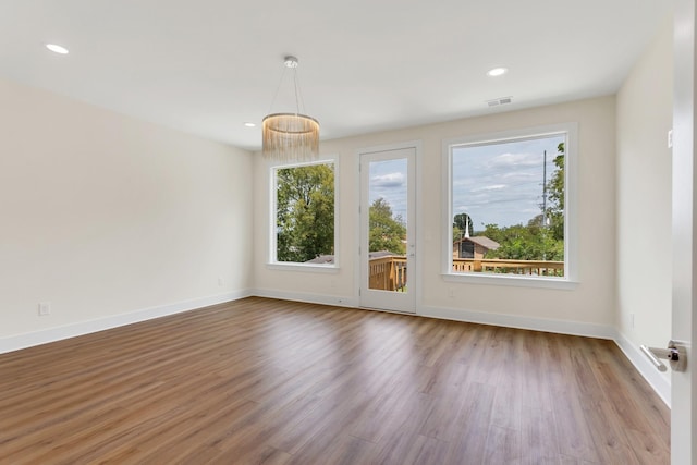 empty room with hardwood / wood-style floors and a wealth of natural light