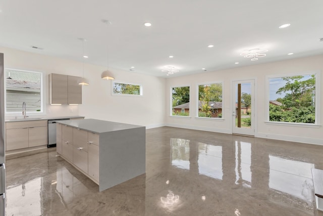 kitchen with pendant lighting, stainless steel dishwasher, sink, and a kitchen island