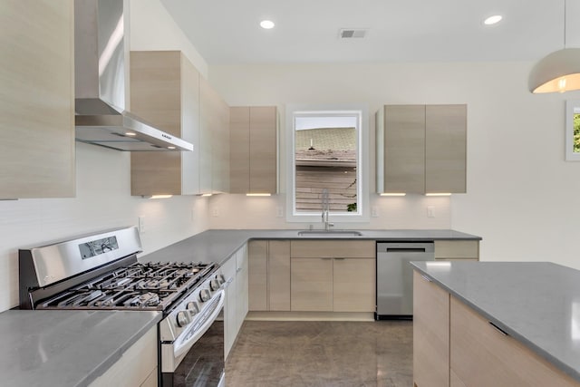 kitchen with wall chimney range hood, stainless steel appliances, sink, and light brown cabinets