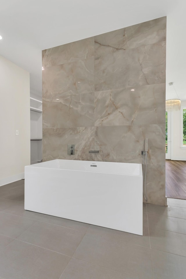 bathroom featuring tile walls, a washtub, and tile patterned floors