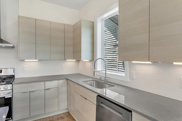 kitchen featuring appliances with stainless steel finishes, sink, and wall chimney range hood