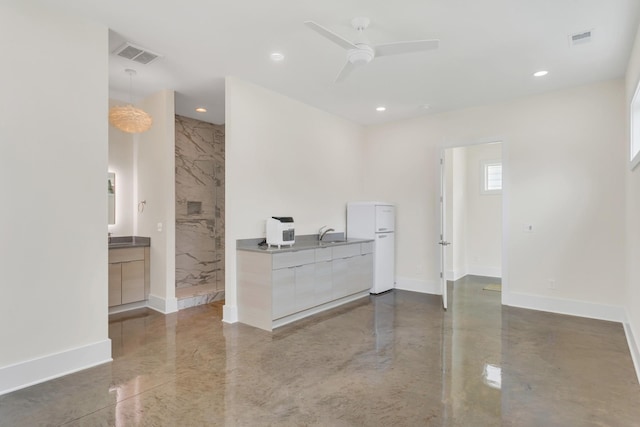 interior space with sink, concrete floors, and ceiling fan