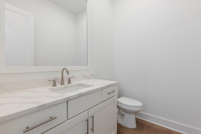 bathroom featuring vanity, hardwood / wood-style flooring, and toilet